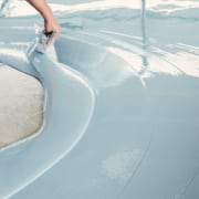 Construction worker smoothing and leveling concrete screed on the floor