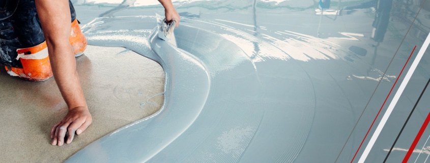 Construction worker smoothing and leveling concrete screed on the floor